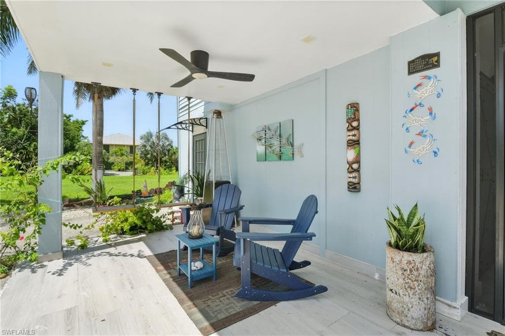 Covered outdoor patio featuring light-toned wood-finish flooring and a ceiling fan