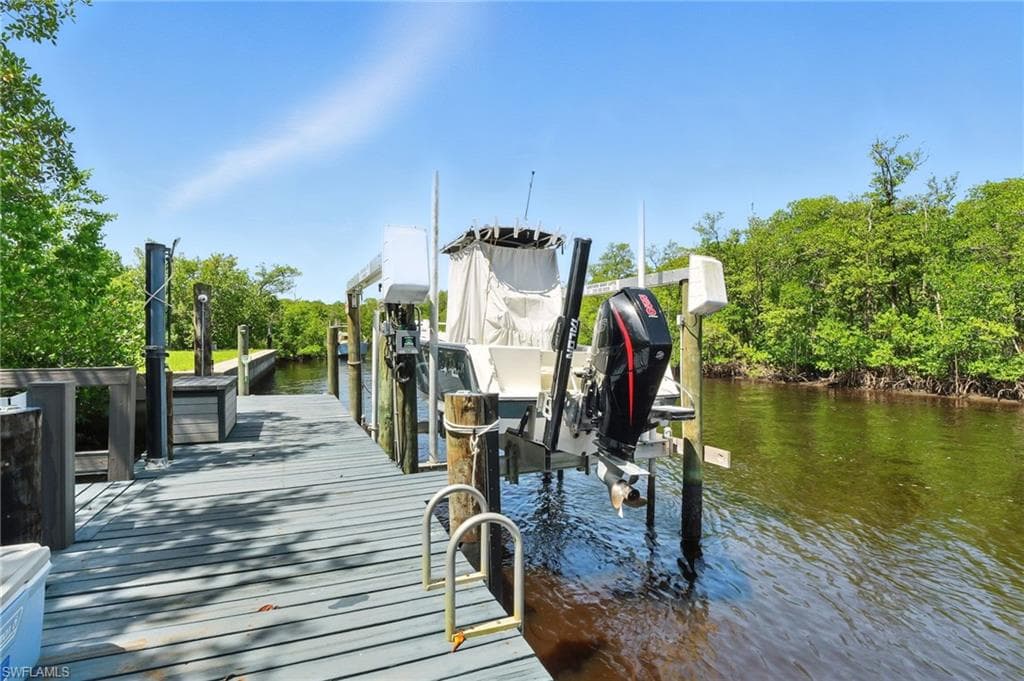 Private dock with a boat lift, featuring durable decking, multiple piling cleats, and direct water access