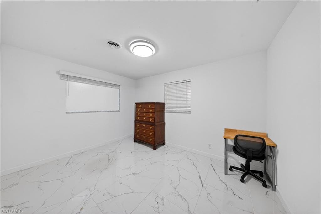 Room featuring white walls, marble-finish tile flooring, a contemporary flush mount ceiling light, and two windows with blinds