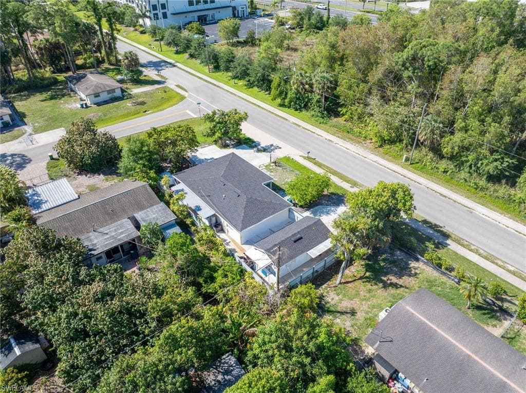 Aerial perspective of a property featuring a dark shingle roof and white exterior