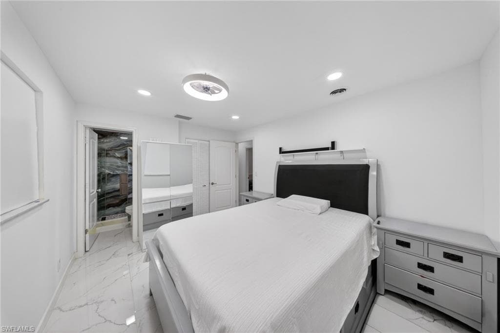 Bedroom featuring white walls and marble-look tile flooring