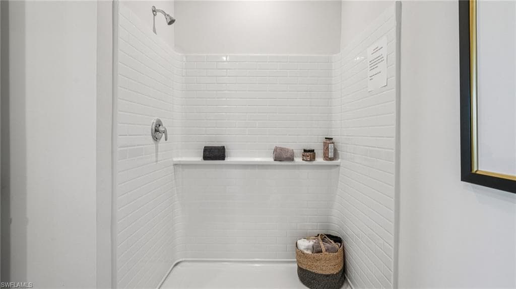 Tiled walk-in shower featuring a chrome showerhead and control handle