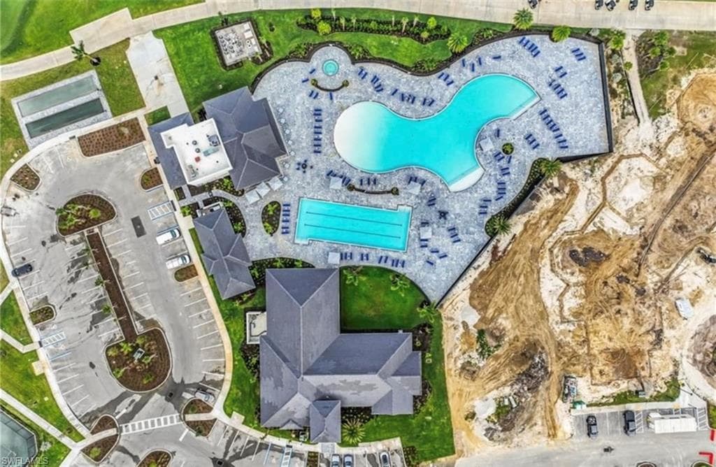Expansive aquatic amenity featuring a large freeform pool, a rectangular lap pool, and a circular spa