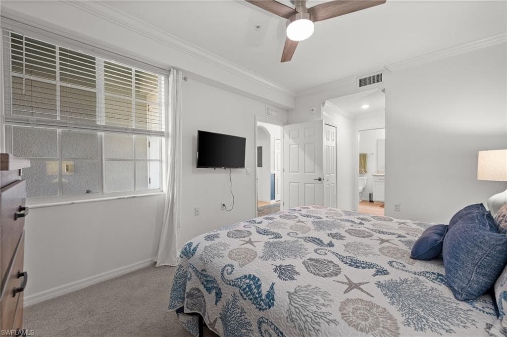 Carpeted bedroom featuring a ceiling fan with light fixture, crown molding, and white window blinds