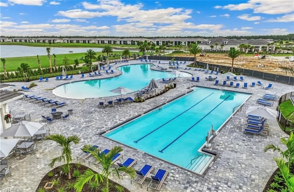 Expansive recreational area featuring a large freeform pool and a rectangular lap pool