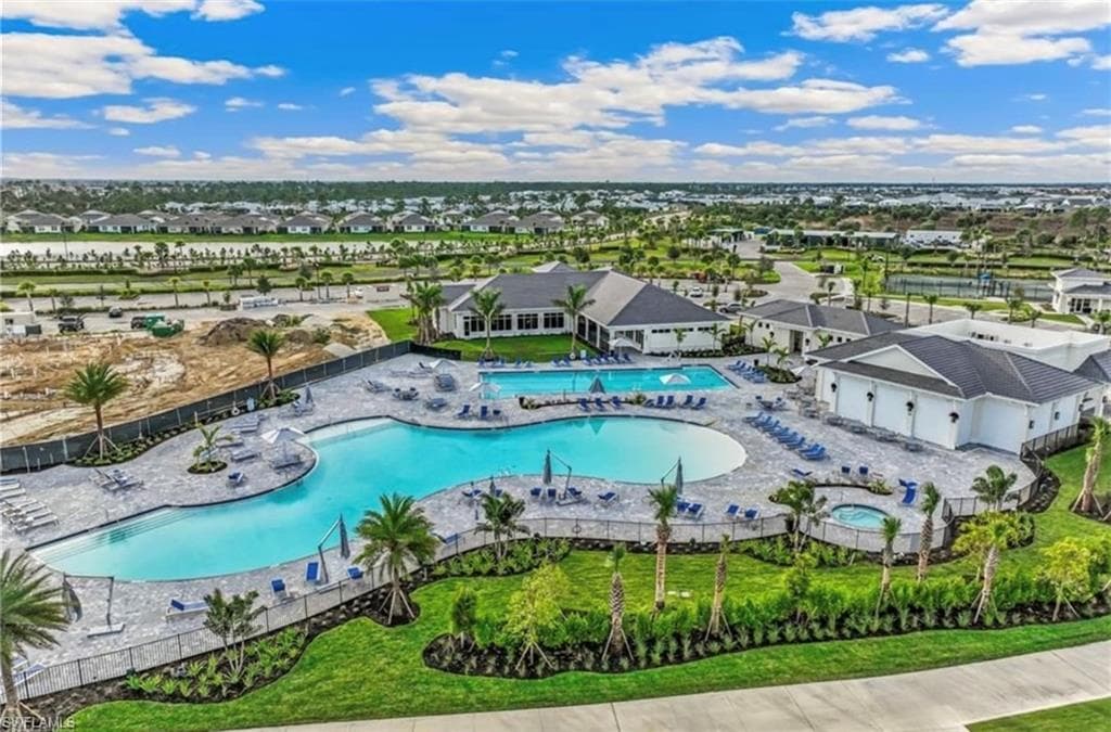 Expansive community pool area featuring a large lagoon-style pool, a rectangular lap pool, and an integrated spa
