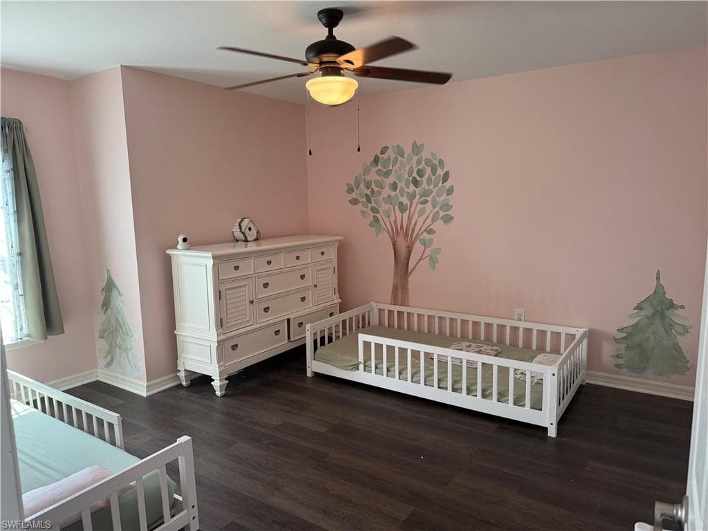 Spacious room featuring wood-finish flooring and a ceiling fan with integrated lighting