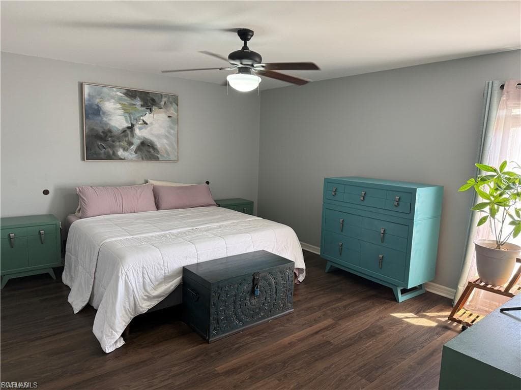 Spacious room featuring wood-finish flooring, light grey walls, and a ceiling fan with integrated lighting