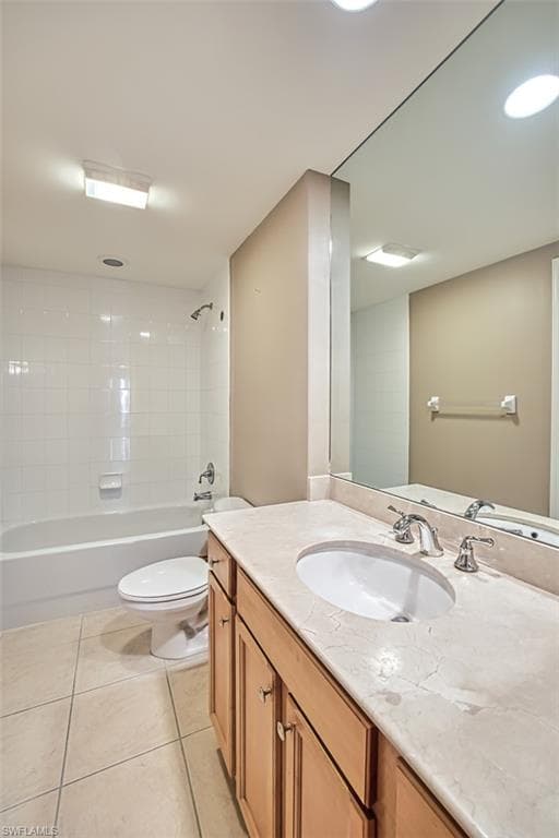Full bathroom featuring tile patterned floors, vanity, tiled shower / bath combo, and toilet