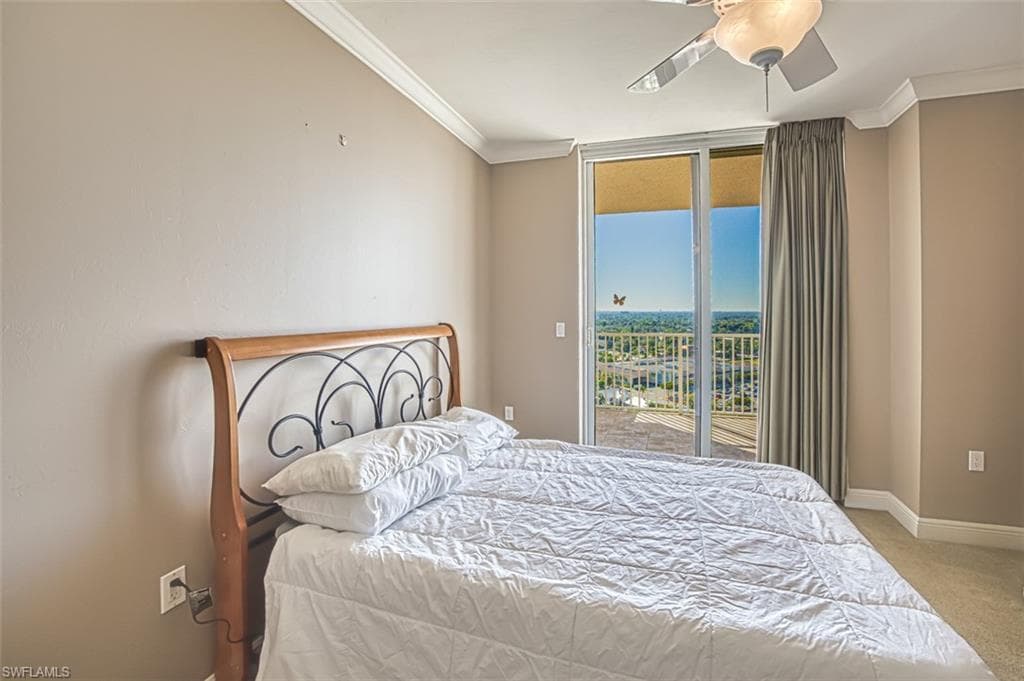 Carpeted bedroom featuring ceiling fan, ornamental molding, and access to outside