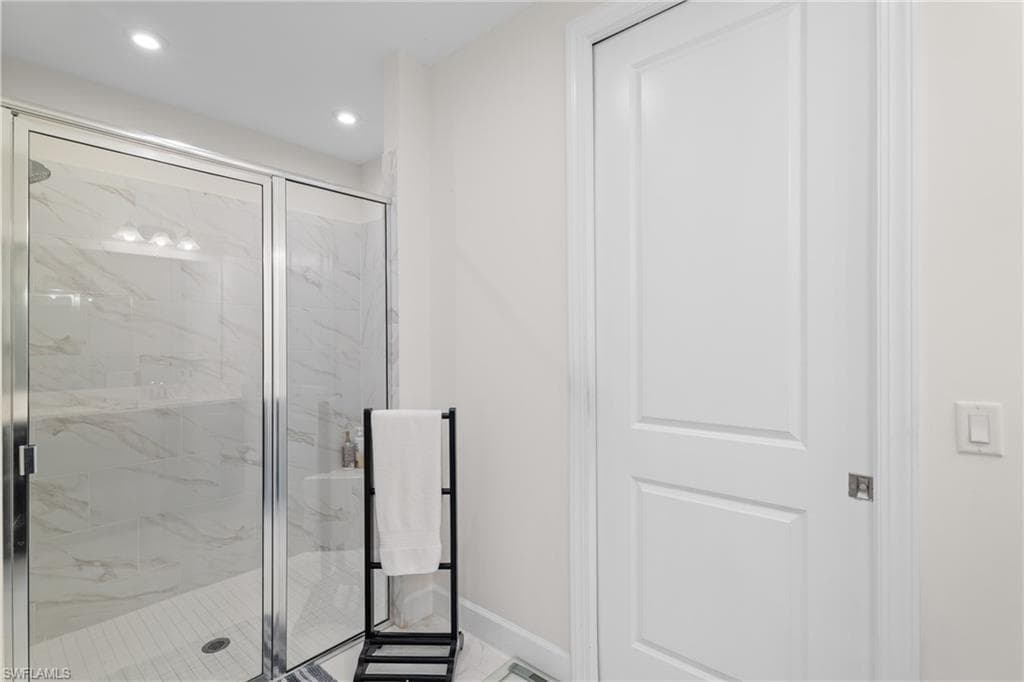 Full bath with light marble finish floors, a marble finish shower, and recessed lighting