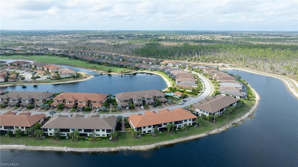Aerial view of property and surrounding area featuring a large body of water and nearby suburban area