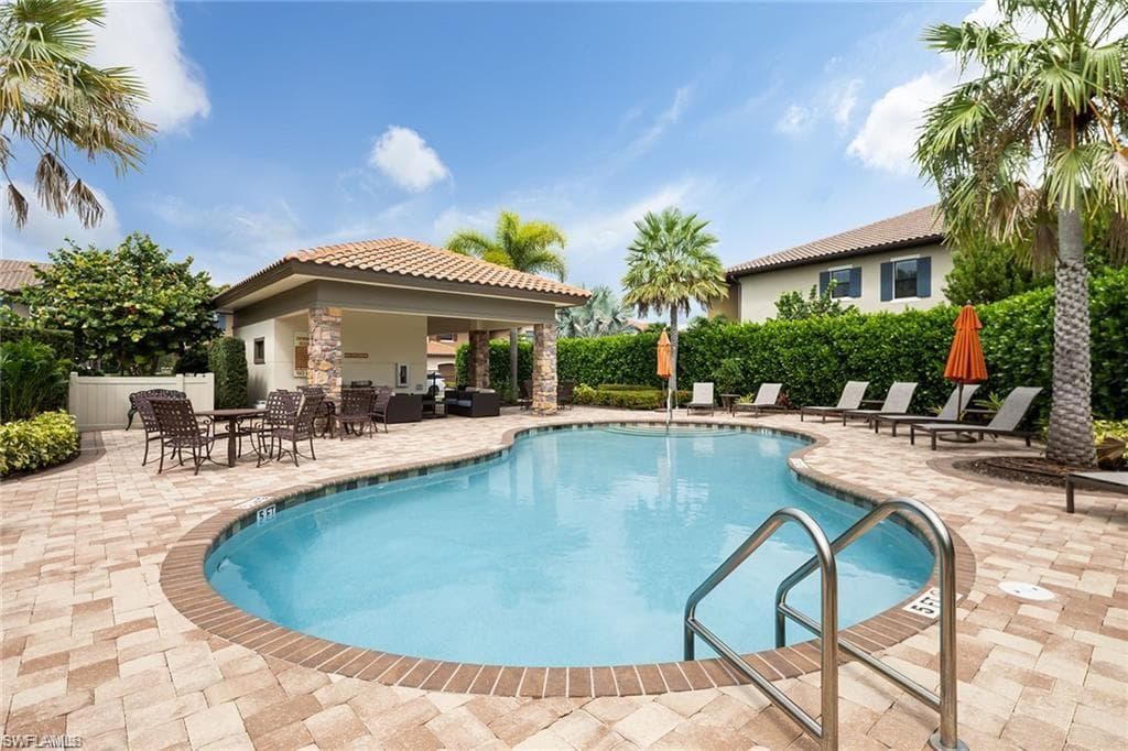 Community pool with a patio area and outdoor lounge area