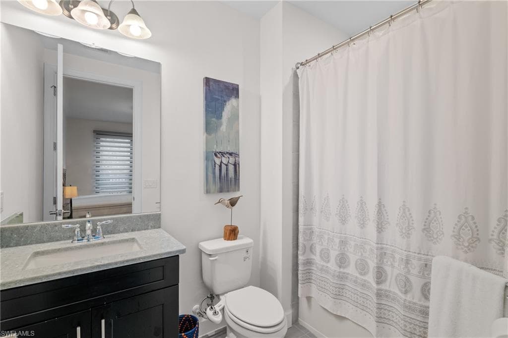 Full bath featuring vanity and shower / tub combo with curtain
