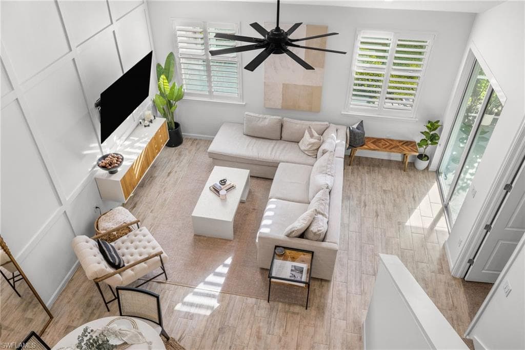 Spacious living area featuring wood-finish flooring and an expansive accent wall with panel molding