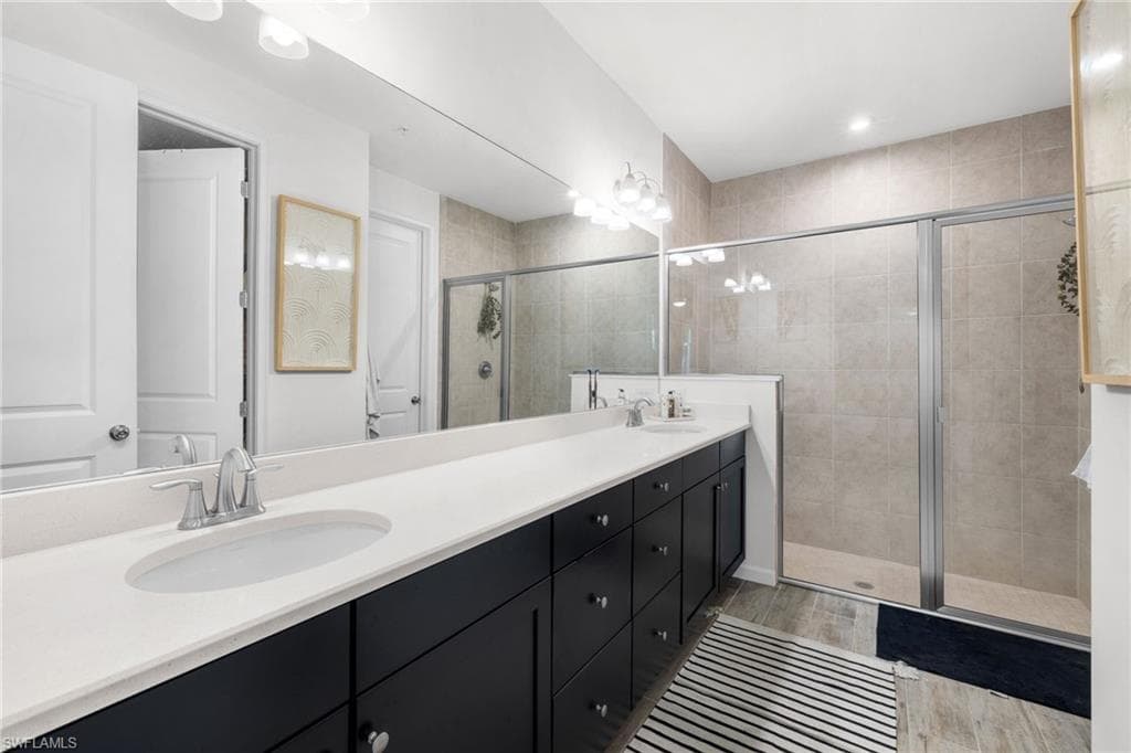 Bathroom featuring a dual vanity with white countertops, dark cabinetry, and brushed nickel fixtures