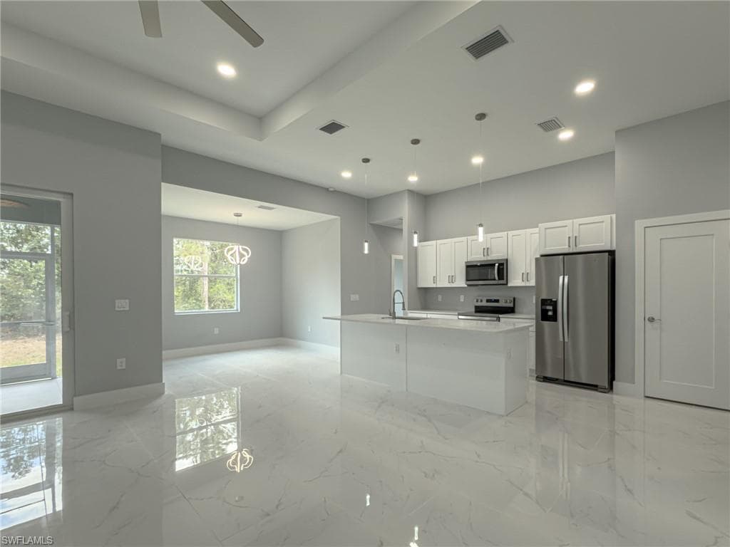 Kitchen featuring ceiling fan, baseboards, stainless steel appliances, and visible vents