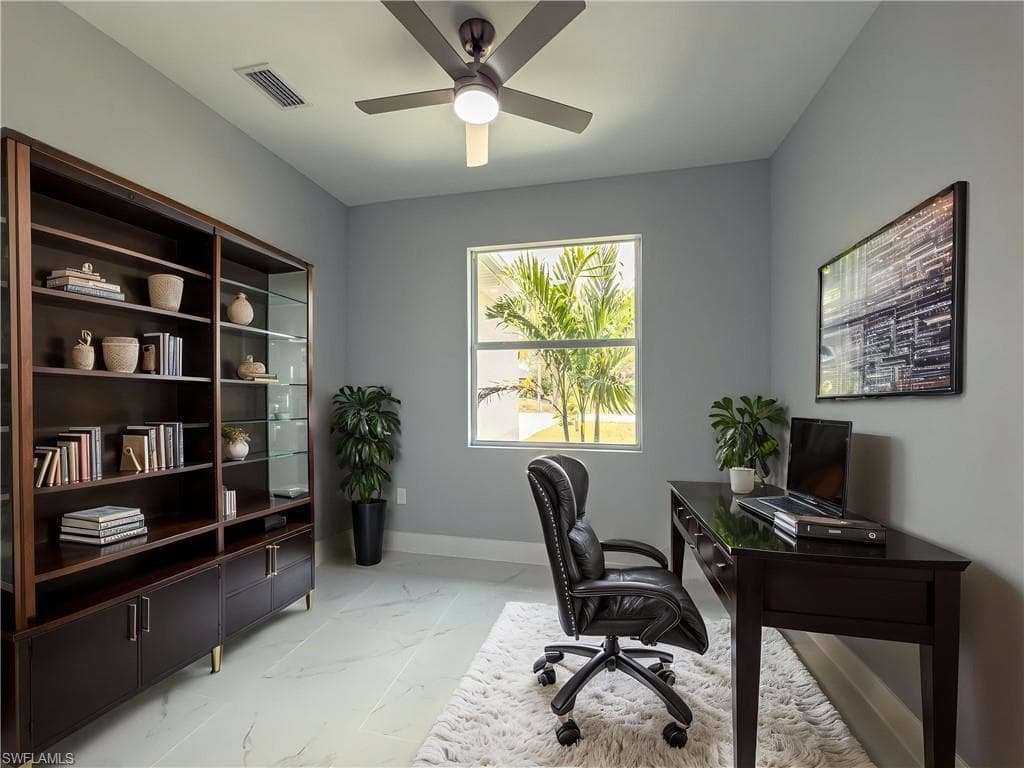 Office with ceiling fan, visible vents, baseboards, and marble finish floor