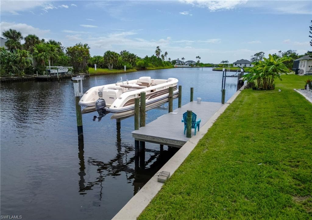 Dock featuring a lawn and a water view