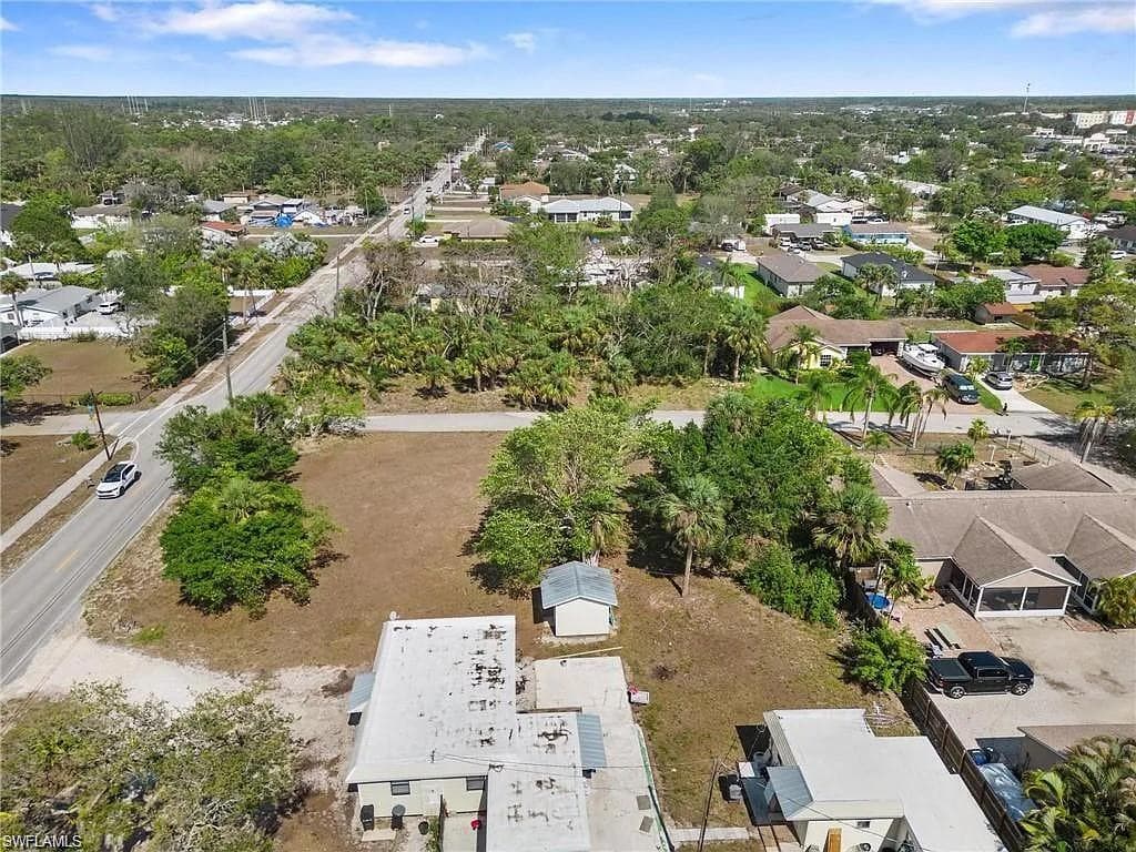 Expansive cleared lot featuring mature trees and a small accessory structure