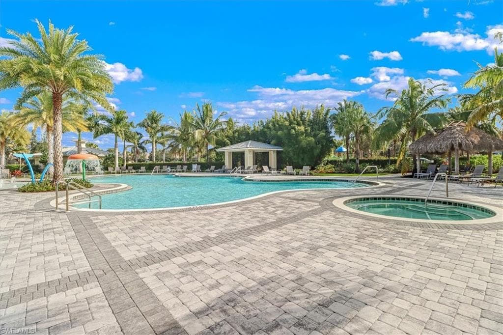 Community pool featuring a gazebo, a hot tub, and a patio area