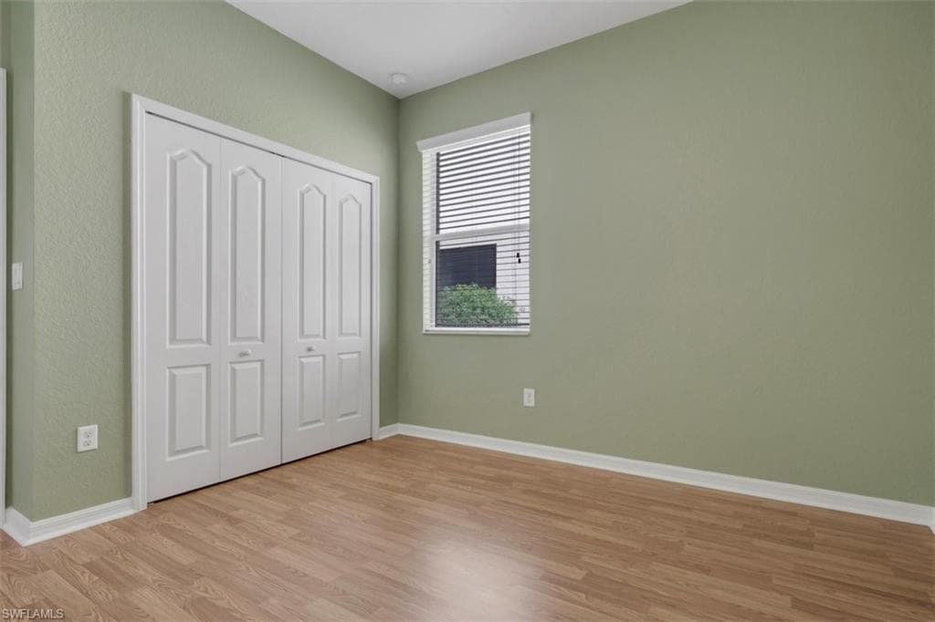 Unfurnished bedroom featuring light wood finished floors and a closet