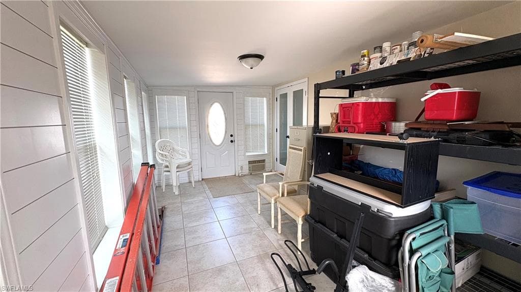Enclosed sunroom is currently used for storage, but will make a wonderful living space as it is air-conditioned and has new windows and doors.