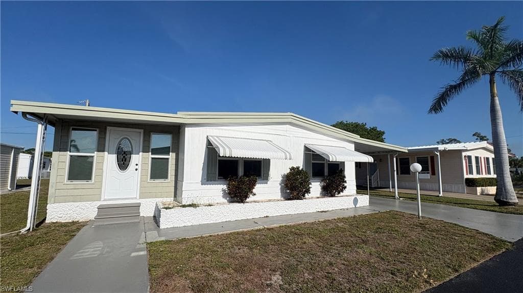 The spacious home features a covered entry, new windows and doors, and a concrete walkway