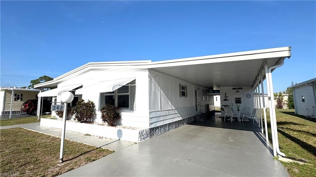 Enjoy the shaded carport, concrete drive, and decorative foundation skirting