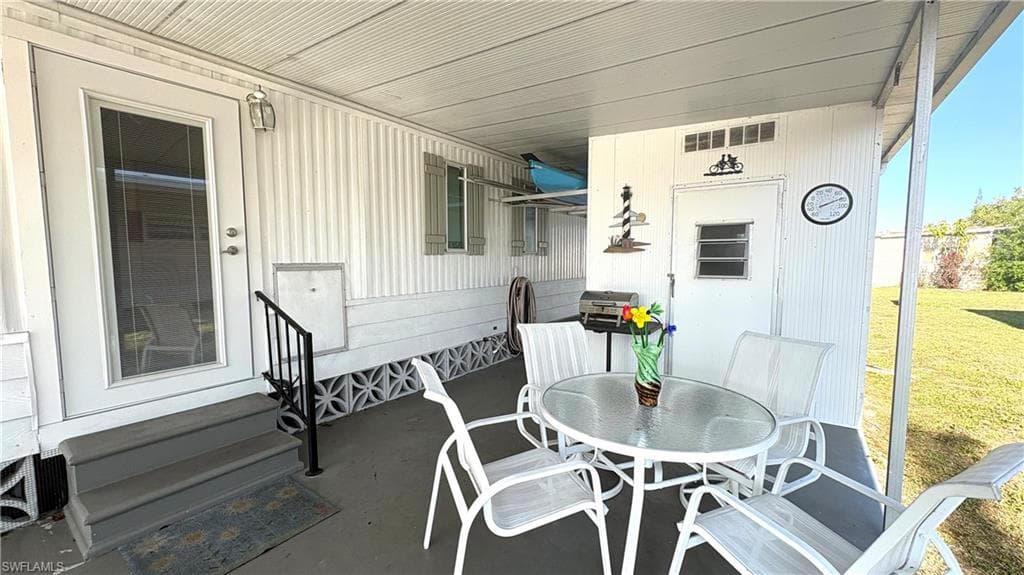 Covered breezeway porch features concrete flooring, solid roof, and adjacent laundry suite.