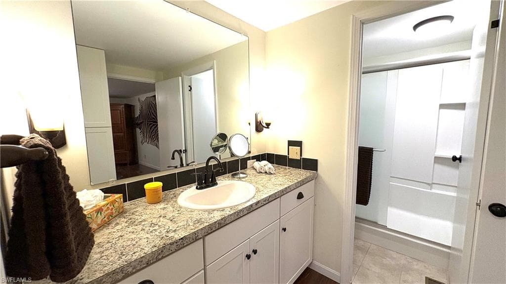 Primary Bathroom vanity with adjacent shower and walk-in closet.