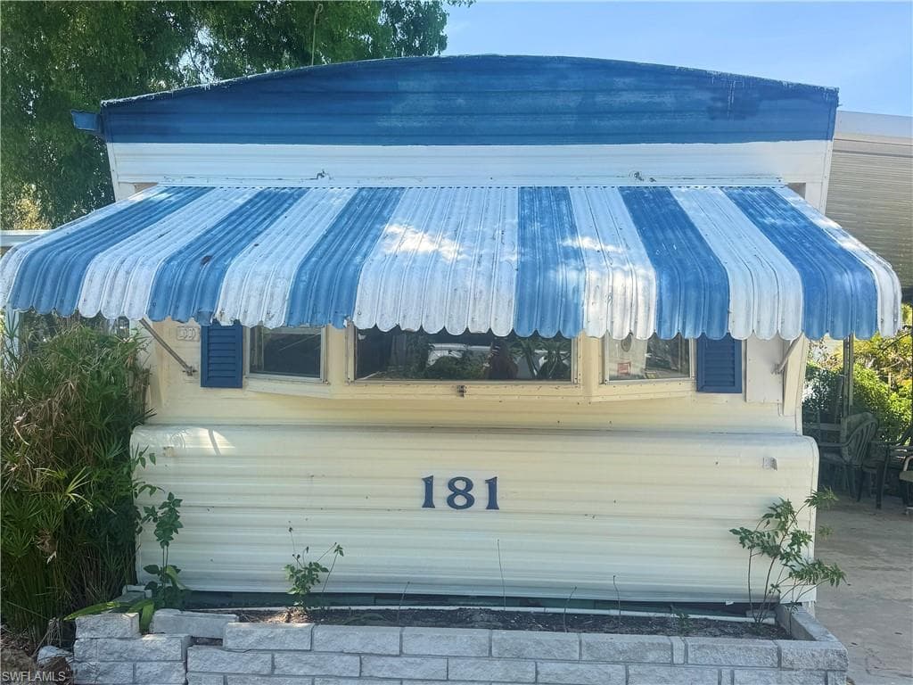 White Manurfactured Home w/blue and white awning