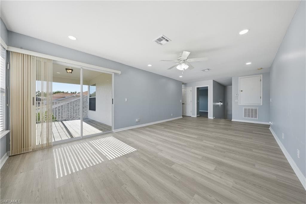 Spacious living area featuring wood-finish flooring, recessed lighting, and a ceiling fan