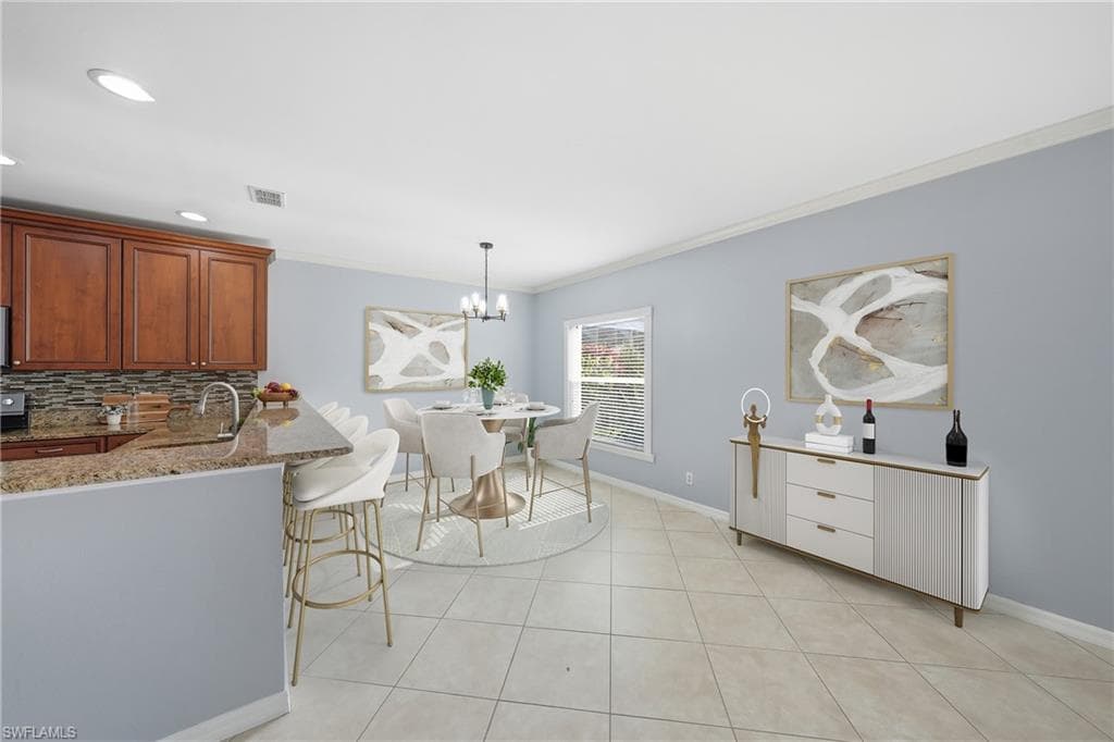 Open-concept living area featuring a kitchen with wood cabinetry, granite countertops, and a tile backsplash