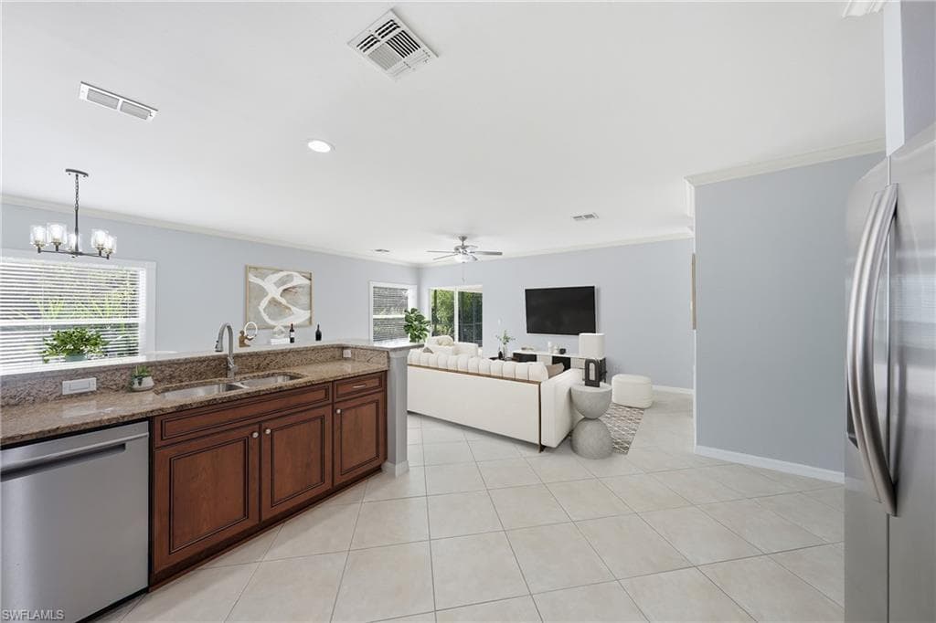 Open-concept kitchen featuring granite countertops, wood cabinetry, and stainless steel appliances