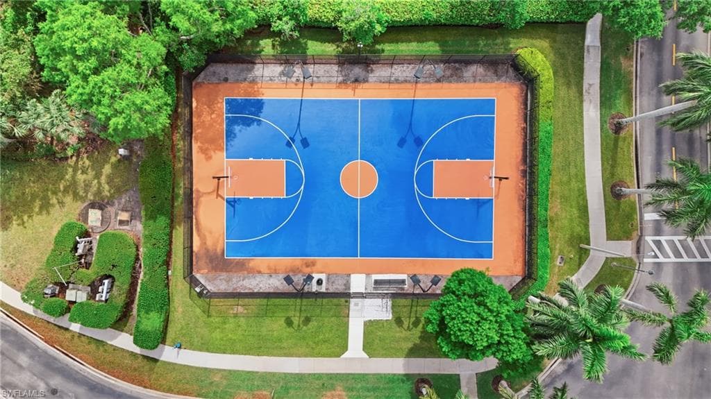 Full-size basketball court featuring a blue playing surface with orange key areas and perimeter, surrounded by a black chain-link fence
