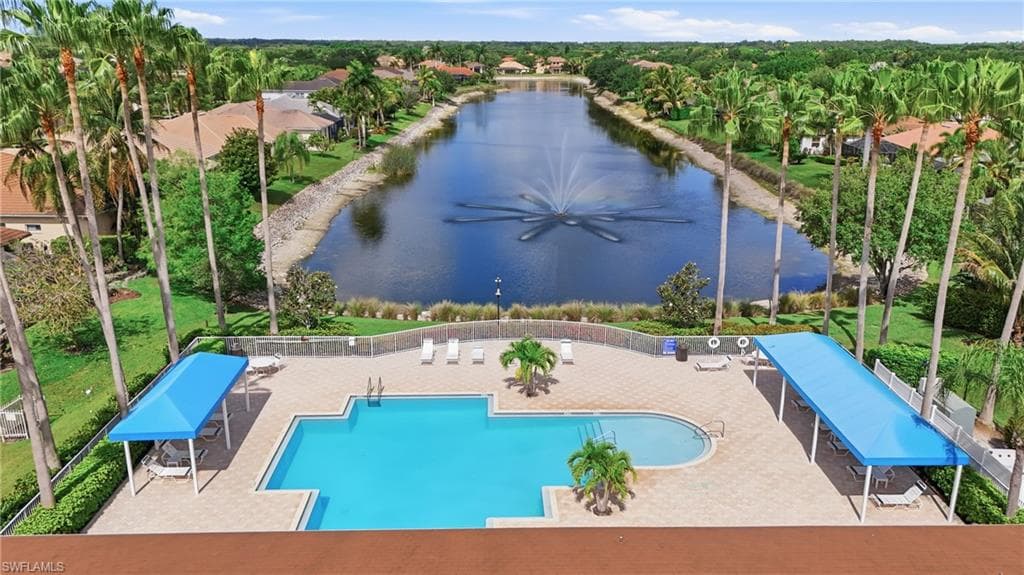Resort-style pool with integrated spa, surrounded by paver decking and shaded lounge areas