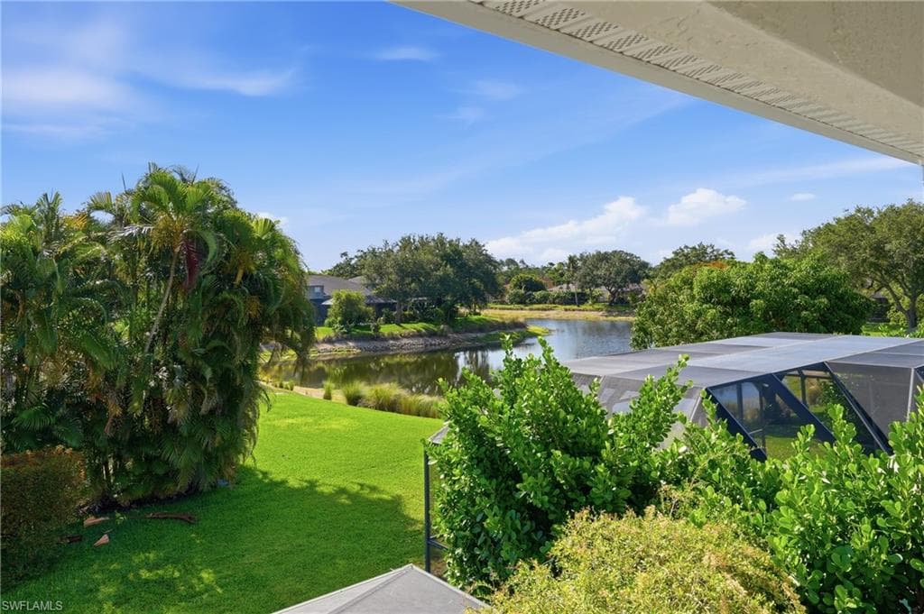 Expansive backyard featuring a green lawn, mature landscaping, and a screened enclosure
