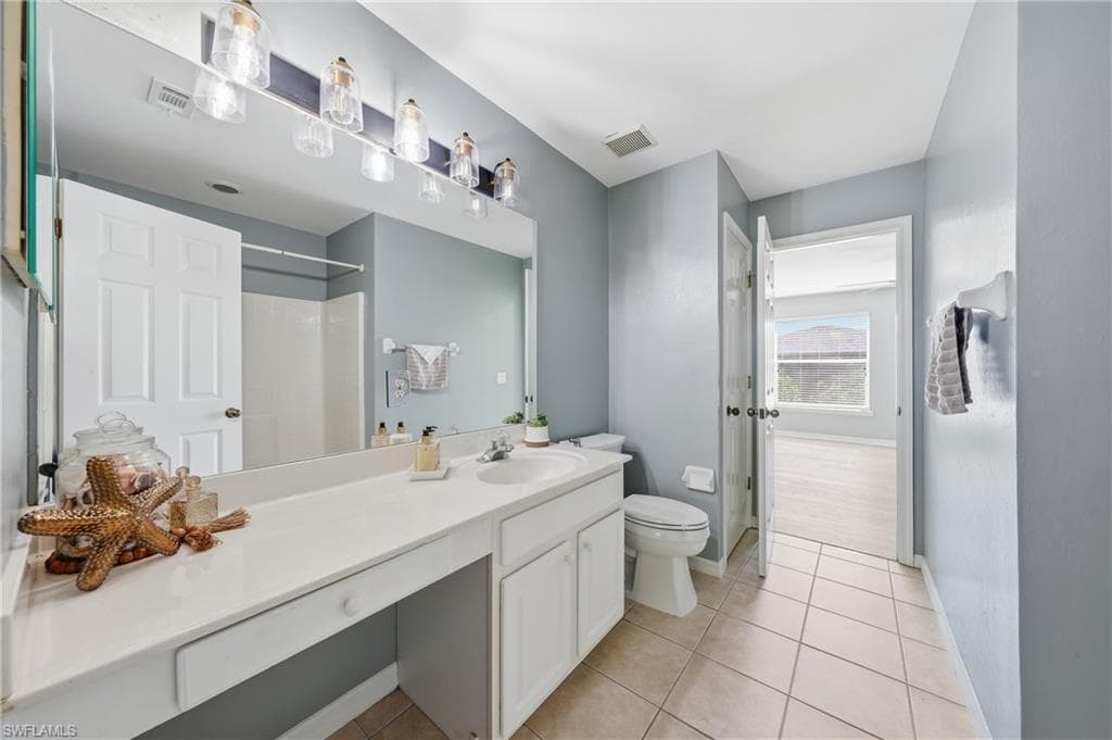 Bathroom featuring a single vanity with an integrated sink, ample counter space, and white cabinetry