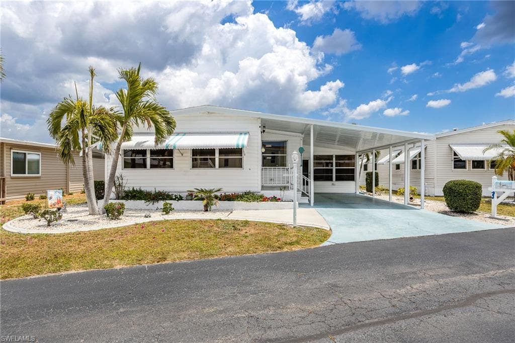 A spacious double-wide home with front Den, 2 bedrm, 2 bath, side lanai with screens & windows PLUS a workshop & lndry room.