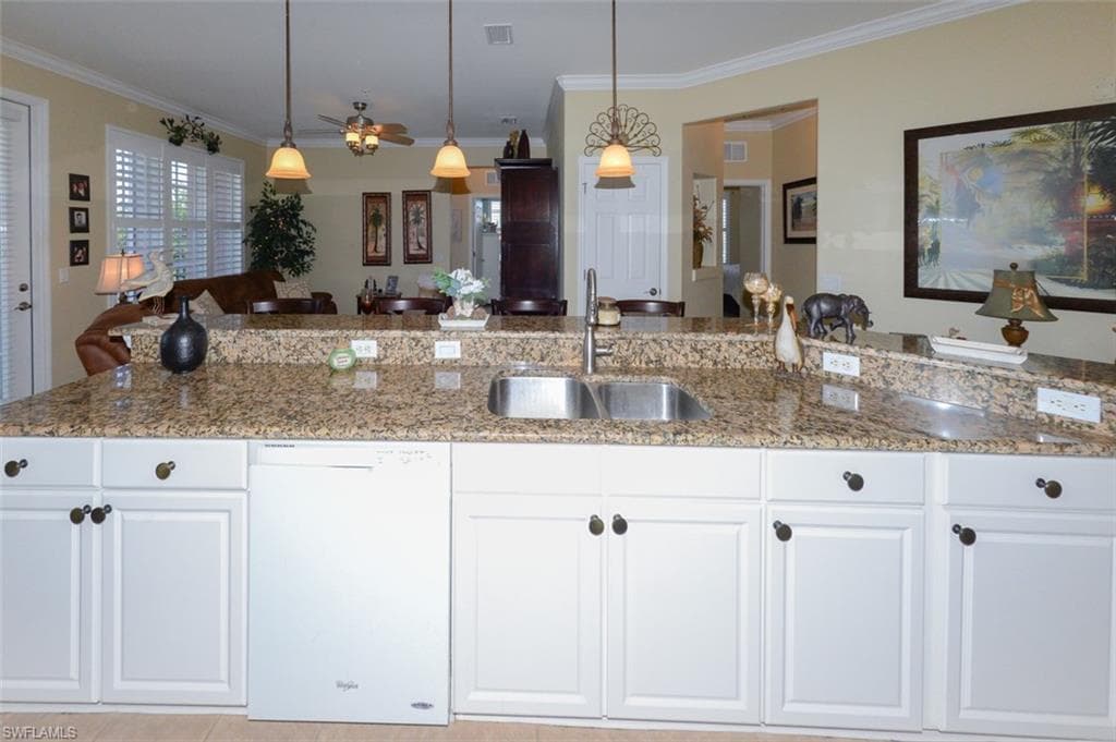 Open Kitchen features tiled flooring, a large Breakfast bar, pantry, 9'4" ceilings, Crown molding, recessed and pendant lighting, White cabinetry, beautiful Granite Countertops, Plantation shutters and Dining area to left.