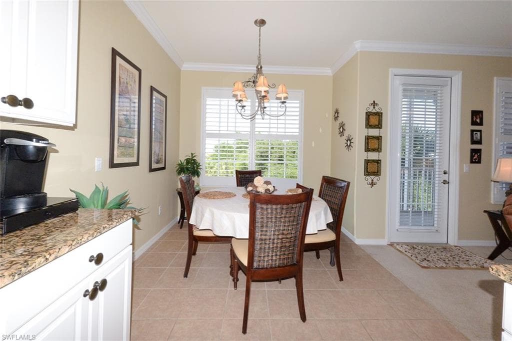 Open Kitchen looking toward dining area and door to Lanai. Features tiled flooring, a Breakfast bar, pantry, 9'4" ceilings, Crown molding, recessed and pendant lighting, White cabinetry, beautiful Granite Countertops, Plantation shutters and more.
