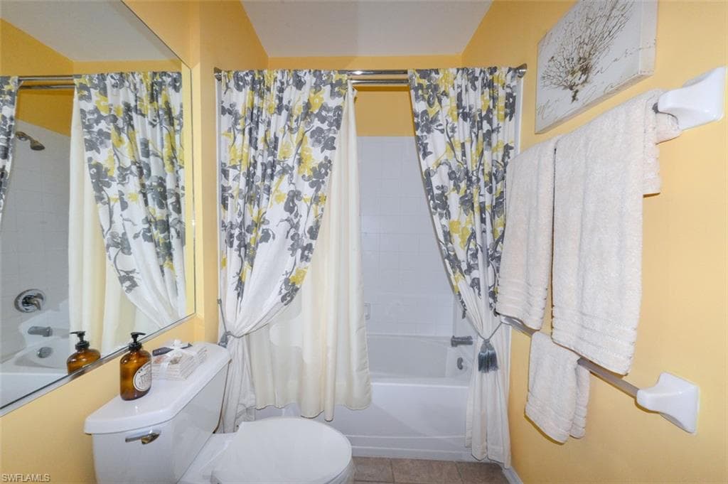 Guest Bathroom with full tub and shower, Tiled floor and upgraded lighting.