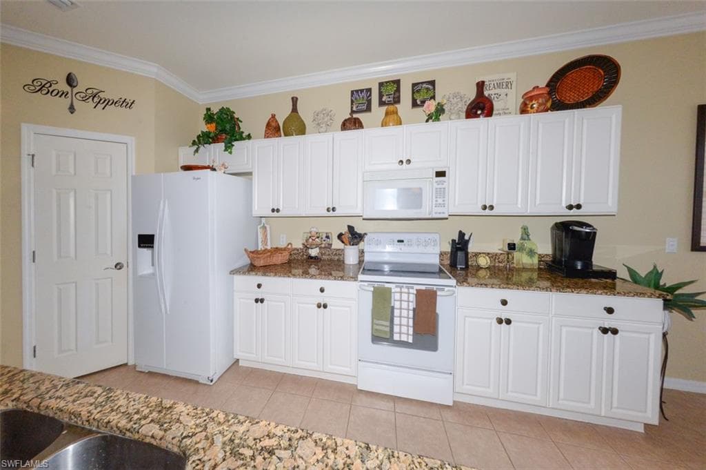 Open Kitchen features tiled flooring, a Breakfast bar, pantry, 9'4" ceilings, Crown molding, recessed and pendant lighting, White cabinetry, beautiful Granite Countertops, Plantation shutters and Dining area to right.