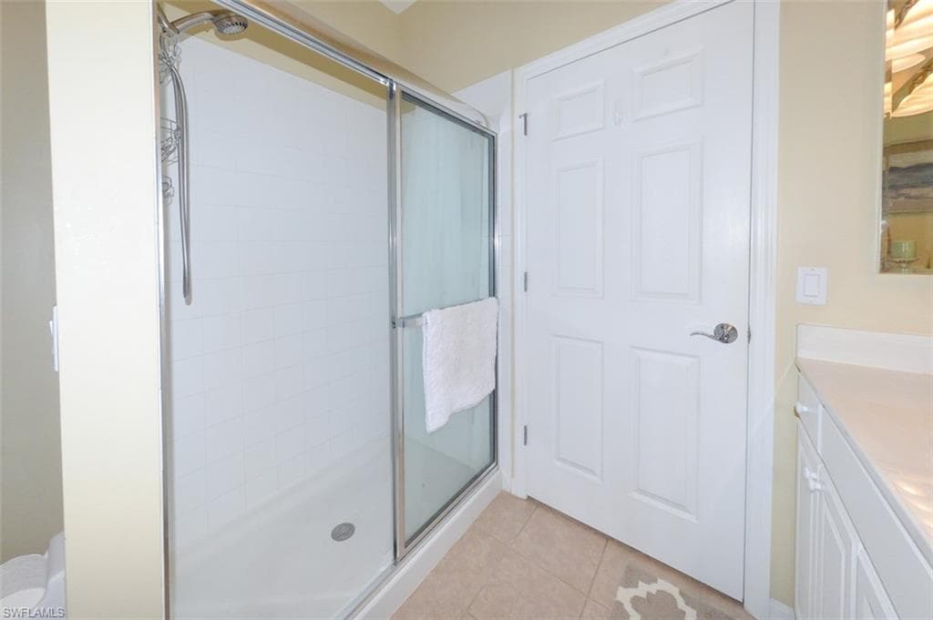 Primary suite bathroom with double sink vanity, upgraded lighting, Walk-in shower, tiled floor and large walk-in closet.