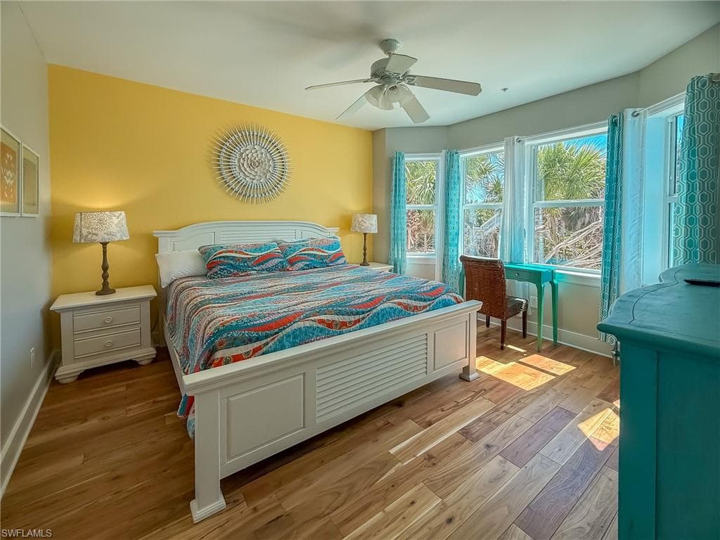 Bedroom featuring light wood-style flooring, a ceiling fan, and baseboards