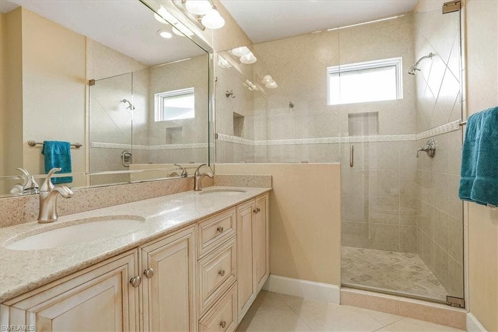 Bathroom featuring a dual vanity with light-toned countertops and undermount sinks
