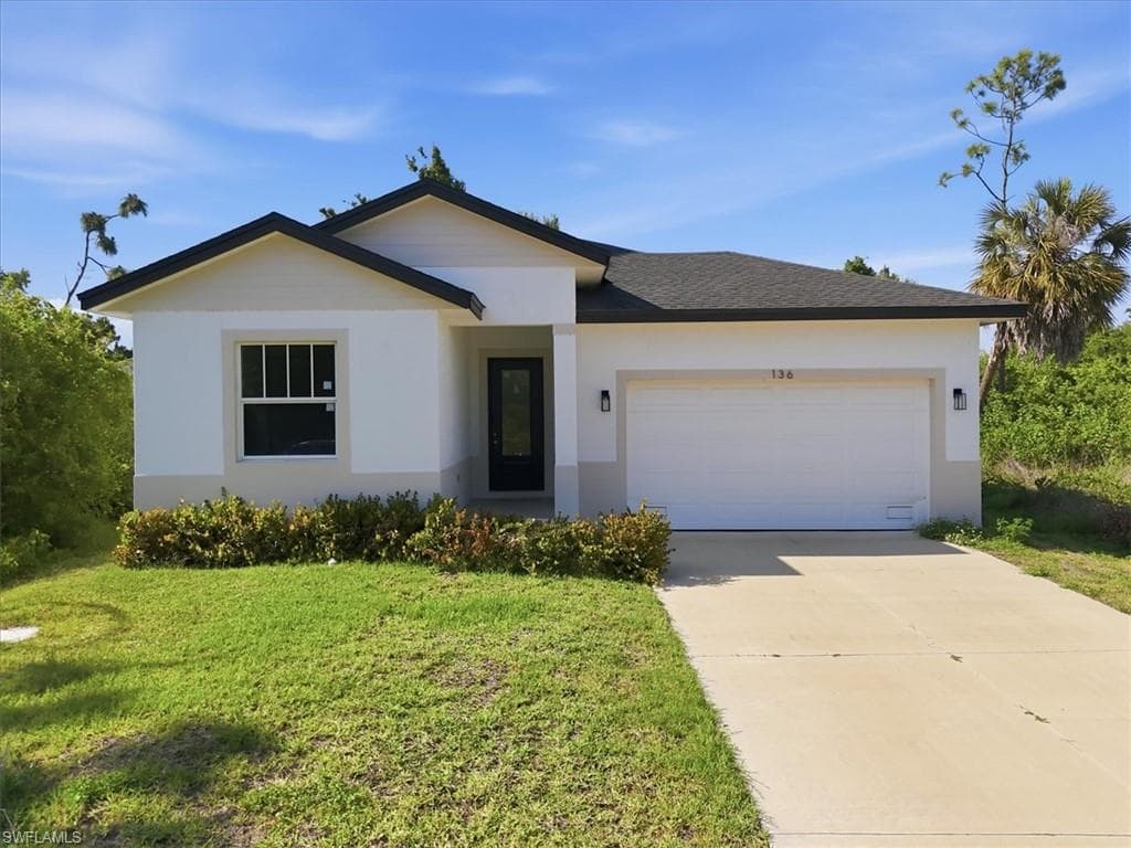 Contemporary single-story residence featuring a white stucco exterior with a light gray foundation, dark roof, and an attached two-car garage