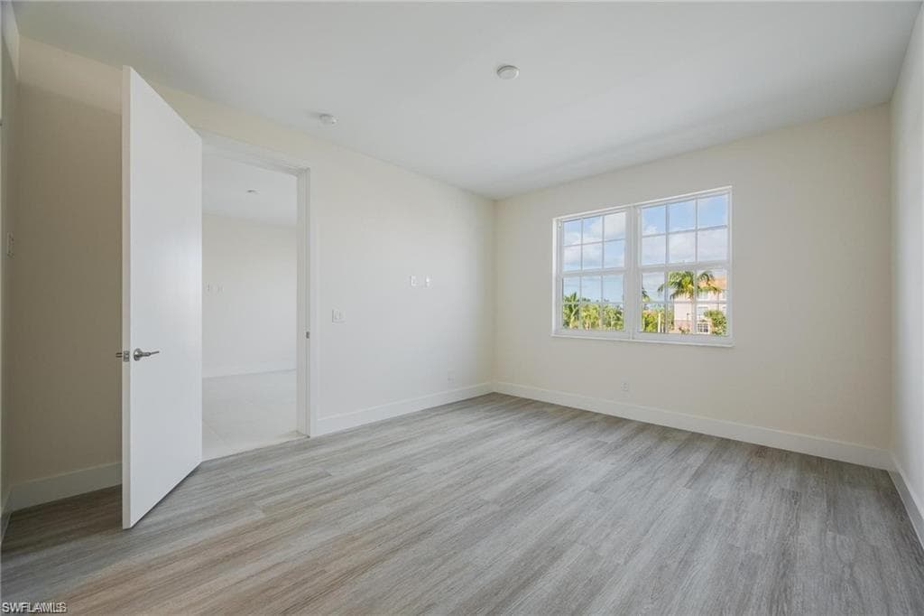 Unfurnished room with baseboards and light wood finished floors