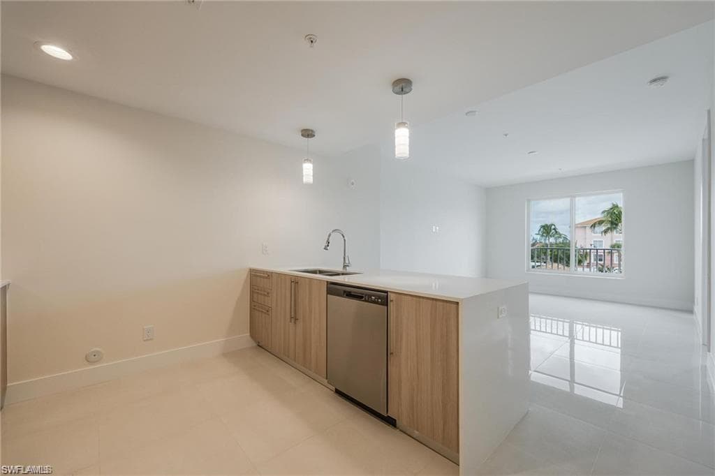 Kitchen featuring a peninsula, light countertops, a sink, modern cabinets, and dishwasher